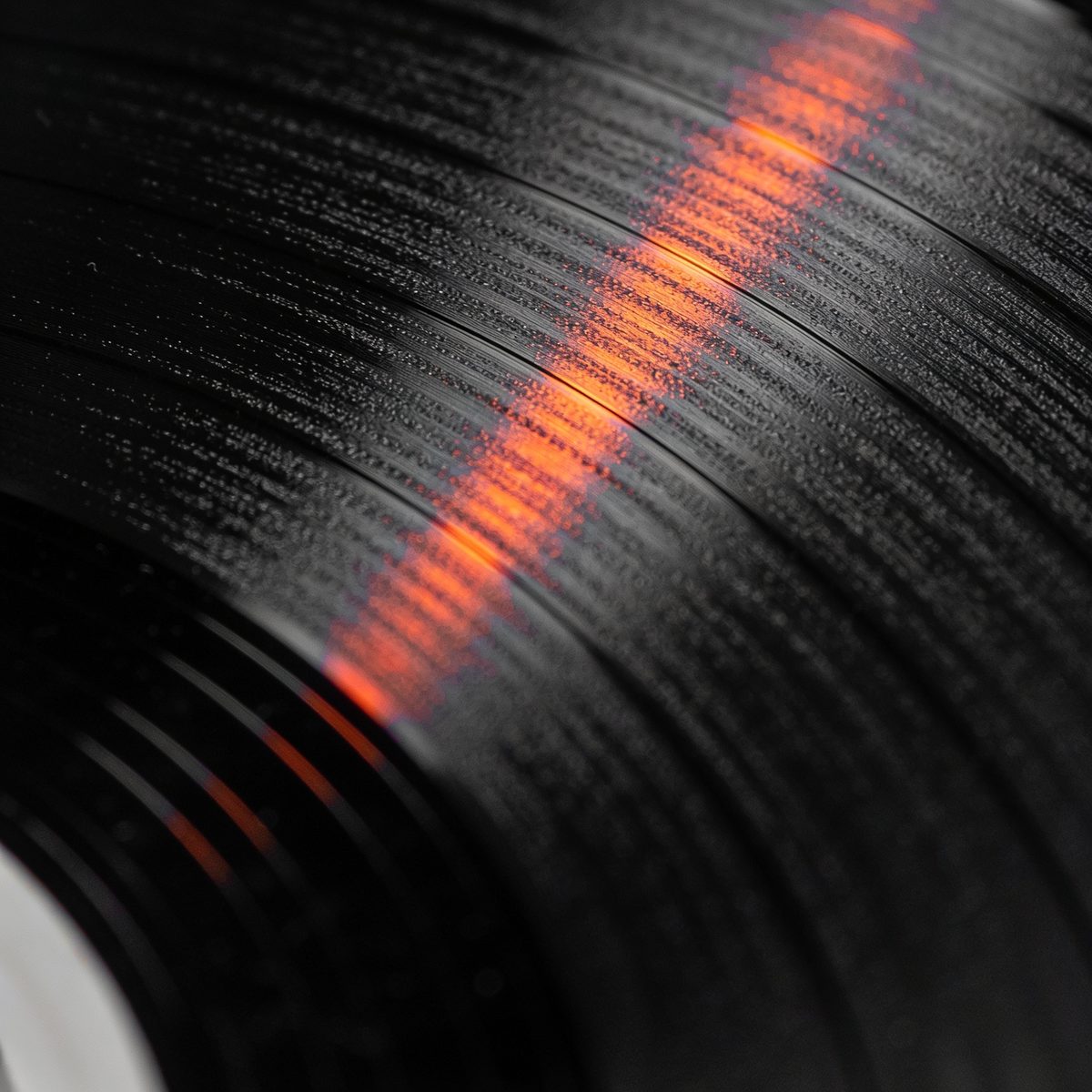 Record grooves catching a streak of vermilion light